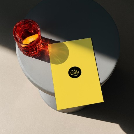 Gelber Flyer A5 als individuelle Menükarte auf grauem Tisch.
